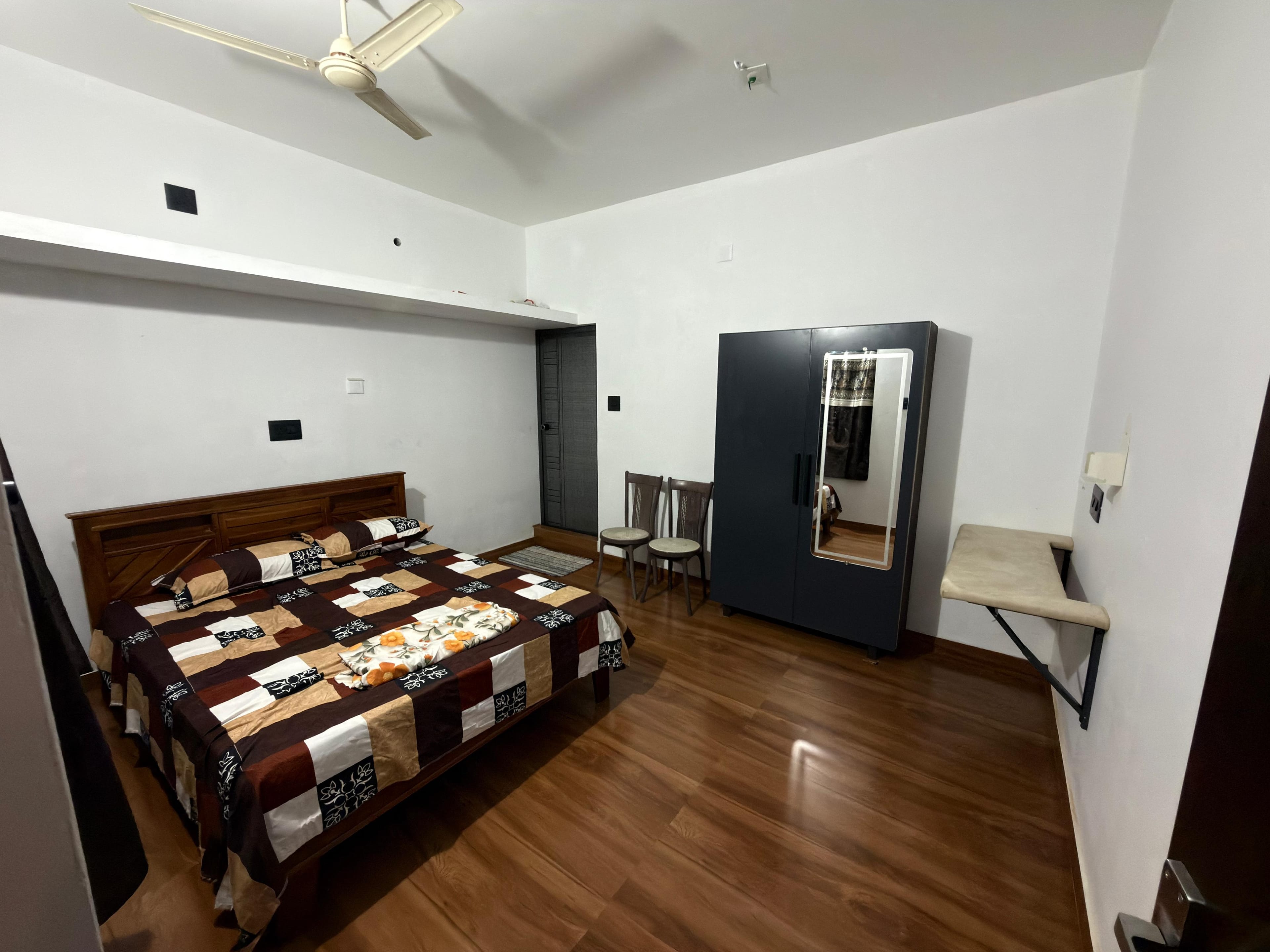 Second bedroom with modern wooden furnishings at Arena Gardens Sreekrishnapuram